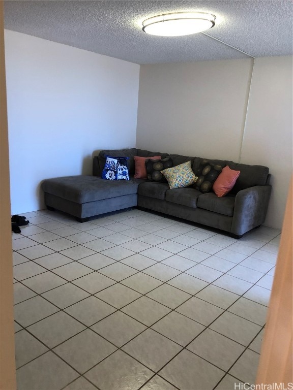 unfurnished living room with a textured ceiling and light tile patterned flooring