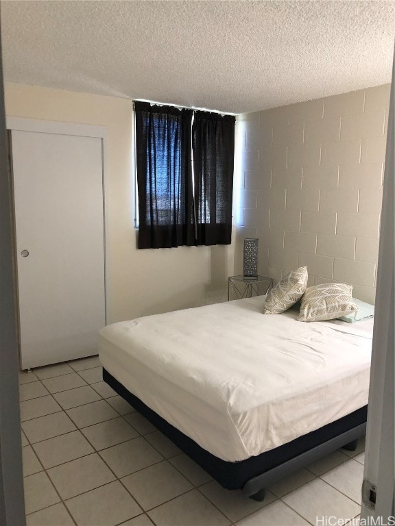 bedroom featuring a textured ceiling and light tile patterned flooring