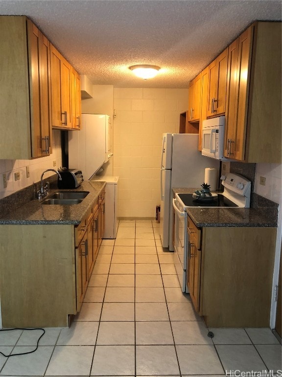 kitchen featuring washer / dryer, light tile patterned flooring, sink, a textured ceiling, and stainless steel electric range oven