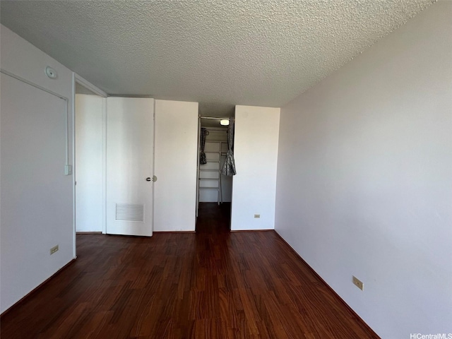 1925 Kalakaua Ave Unit 1206, Honolulu, HI 96815 - unfurnished bedroom with wood finished floors, a textured ceiling, a closet, and a walk in closet