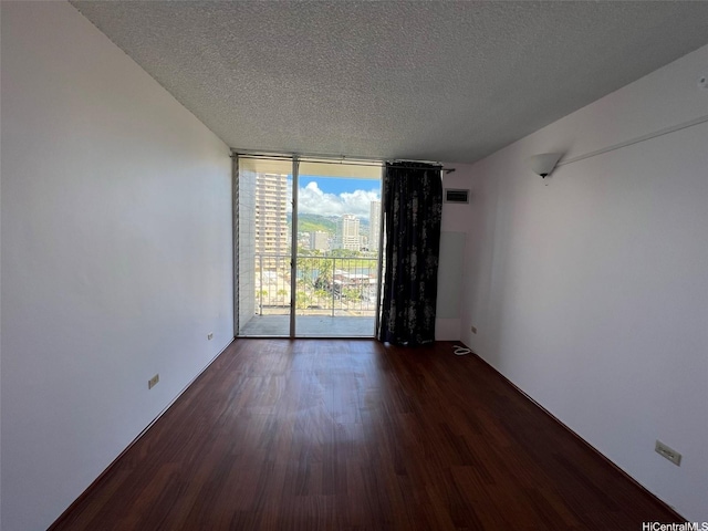 1925 Kalakaua Ave Unit 1206, Honolulu, HI 96815 - empty room with expansive windows, a textured ceiling, and dark wood-style flooring