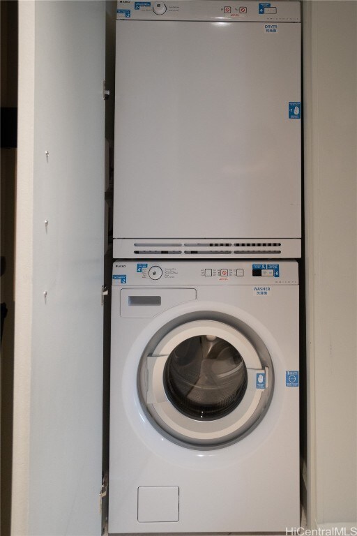 clothes washing area featuring stacked washer and dryer