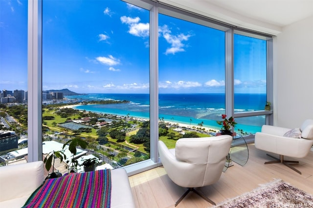 sunroom with a water view and a beach view