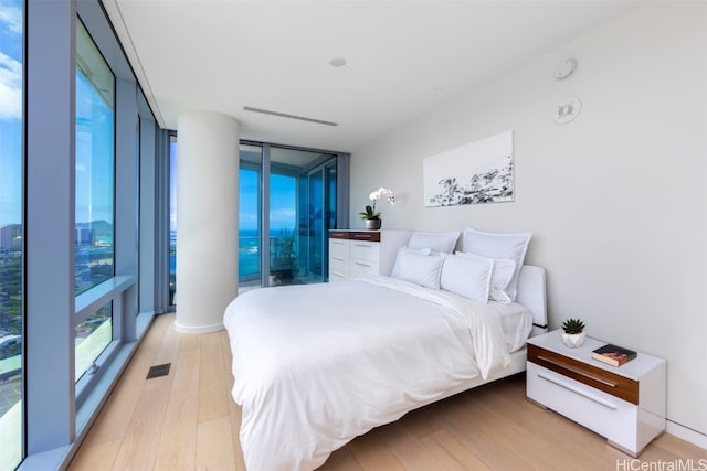 bedroom featuring floor to ceiling windows and light wood-type flooring