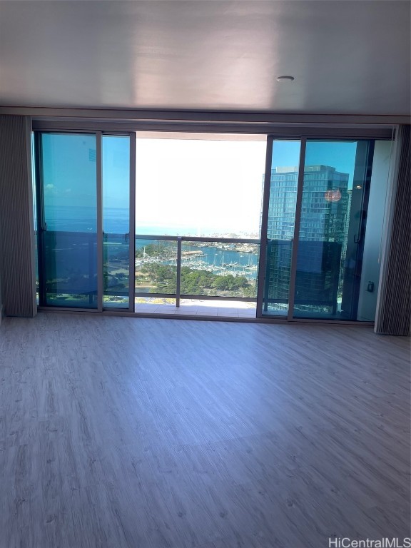 spare room featuring expansive windows and hardwood / wood-style flooring