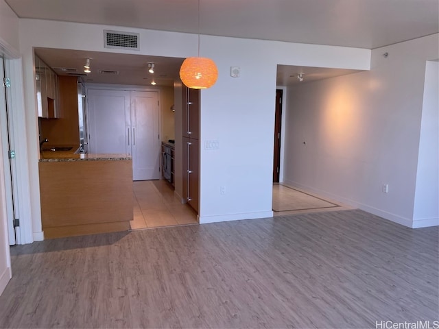 unfurnished room featuring light hardwood / wood-style floors and sink