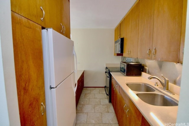 kitchen with black electric range oven, sink, and white fridge