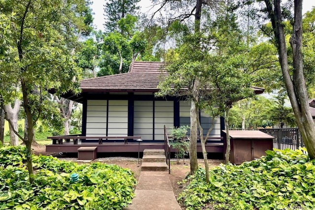 back of property with a deck and a jacuzzi