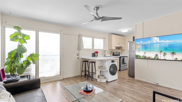 interior space with sink, ceiling fan, and light hardwood / wood-style flooring