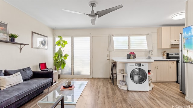 interior space with washer / dryer, sink, light wood-type flooring, and ceiling fan