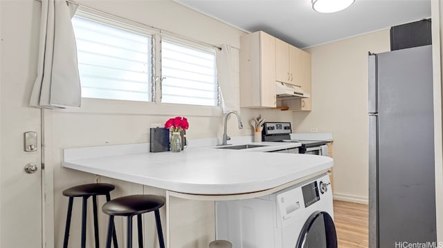 kitchen with stainless steel appliances, sink, a kitchen bar, premium range hood, and light hardwood / wood-style floors