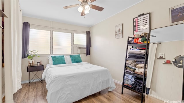 bedroom with cooling unit, light wood-type flooring, and ceiling fan