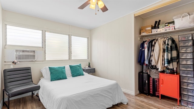 bedroom with a closet, ceiling fan, cooling unit, and hardwood / wood-style floors