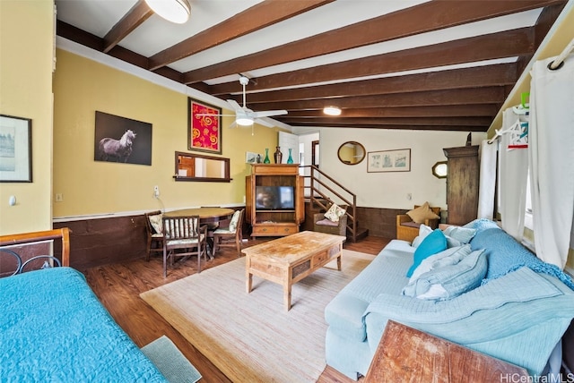 living room featuring wood walls, hardwood / wood-style floors, vaulted ceiling with beams, and ceiling fan