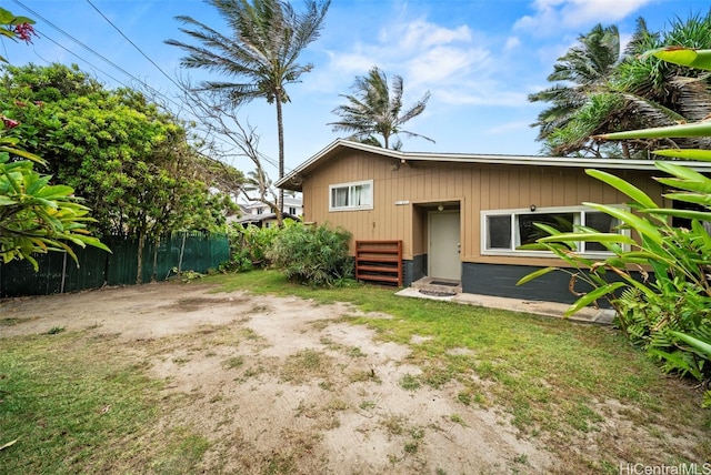 rear view of property featuring a yard