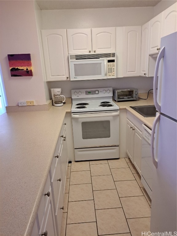 kitchen with white cabinetry, sink, light tile patterned floors, and white appliances