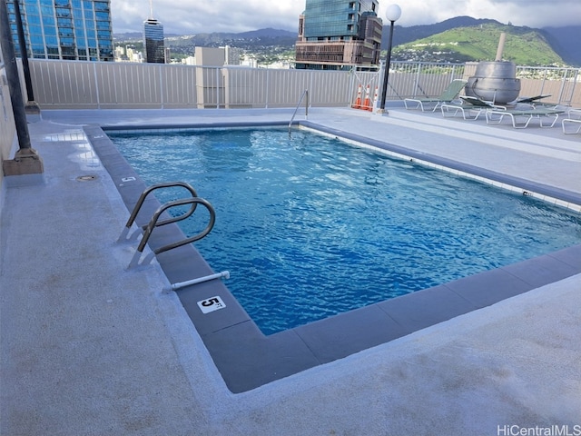 view of swimming pool with a mountain view and a patio