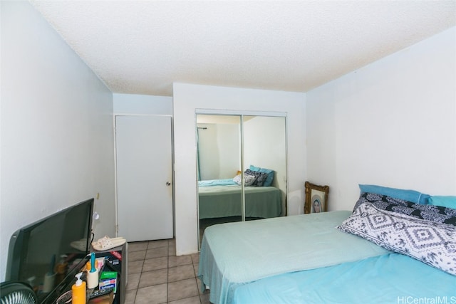 tiled bedroom featuring a closet and a textured ceiling