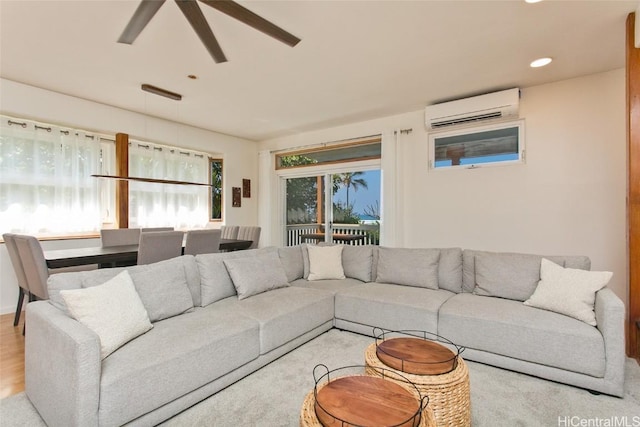 living room with ceiling fan, light hardwood / wood-style floors, and a wall mounted air conditioner