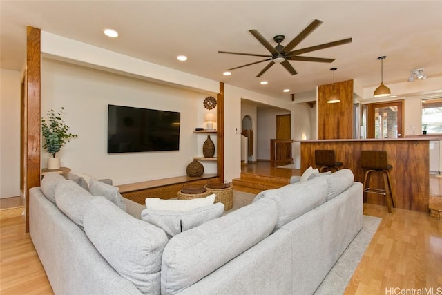 living room featuring ceiling fan and light hardwood / wood-style flooring