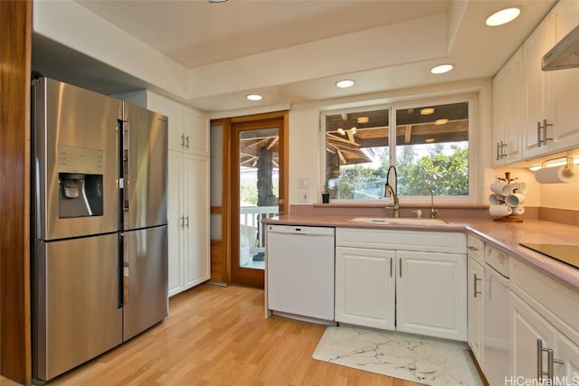 kitchen with white cabinets, plenty of natural light, white dishwasher, and stainless steel refrigerator with ice dispenser