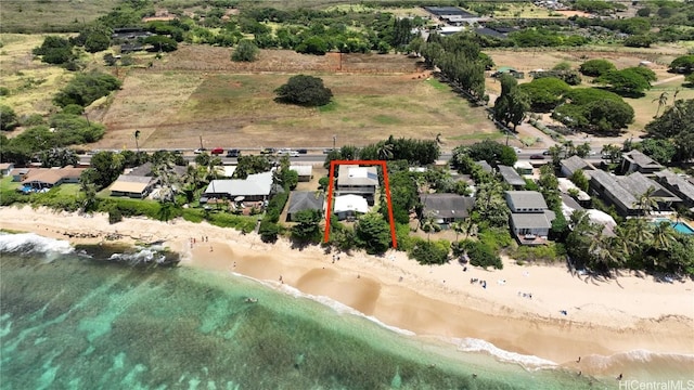 birds eye view of property featuring a beach view and a water view