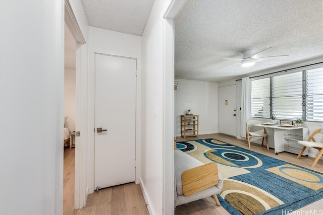 entrance foyer with a textured ceiling, hardwood / wood-style flooring, and ceiling fan