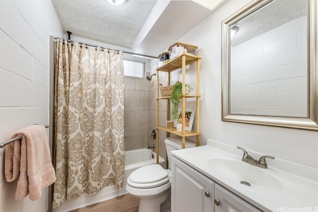 full bathroom with shower / bath combo, toilet, hardwood / wood-style floors, vanity, and a textured ceiling