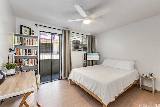 bedroom with light hardwood / wood-style flooring, a textured ceiling, access to outside, and ceiling fan