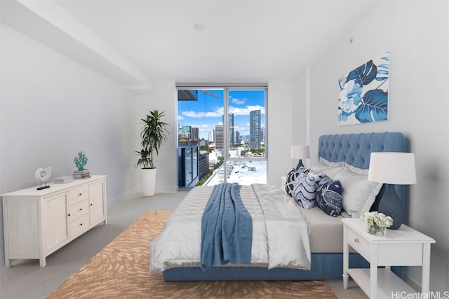 bedroom with access to outside, carpet, and a wall of windows