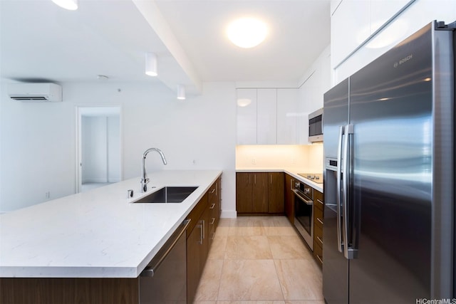 kitchen featuring a sink, a wall mounted air conditioner, stainless steel appliances, a peninsula, and modern cabinets