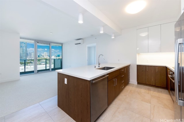 kitchen with appliances with stainless steel finishes, sink, white cabinets, light colored carpet, and floor to ceiling windows