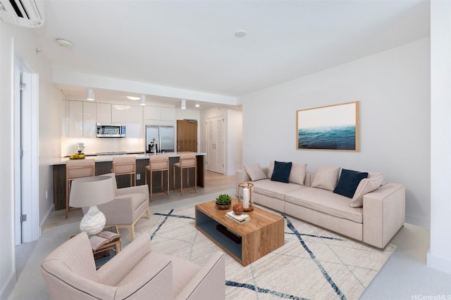 living area featuring baseboards and a wall mounted air conditioner