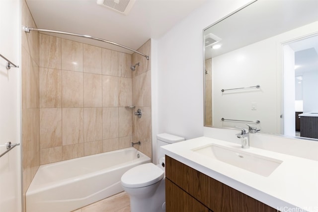 full bathroom with tile patterned flooring, vanity, tiled shower / bath combo, and toilet