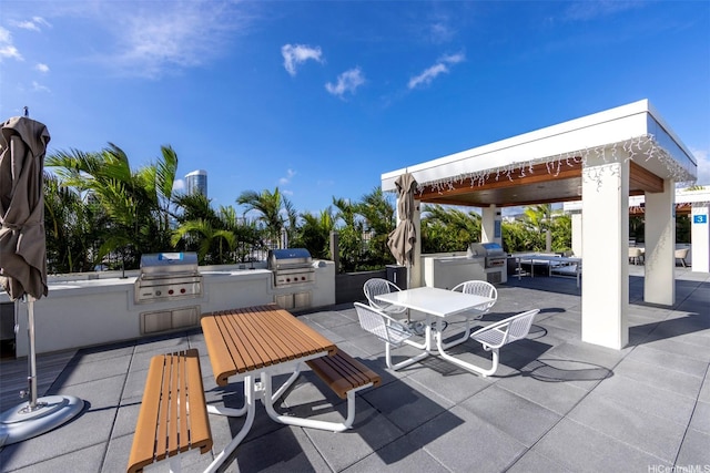 view of patio featuring an outdoor kitchen, a gazebo, outdoor dining area, and area for grilling