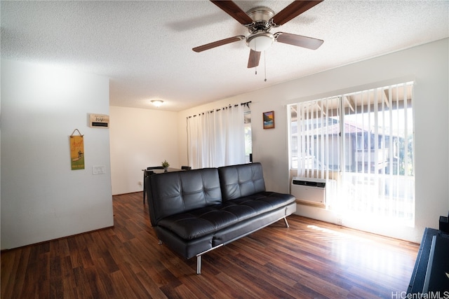 living room featuring dark wood-type flooring, ceiling fan, a textured ceiling, and a wall mounted air conditioner