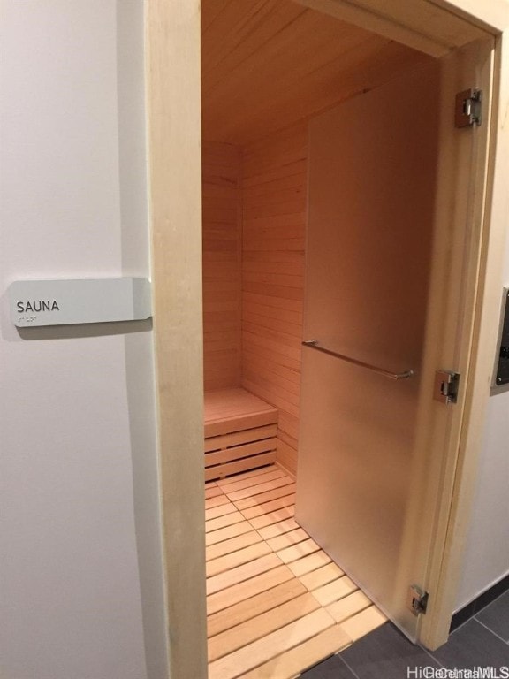 view of sauna featuring tile patterned floors and wooden walls