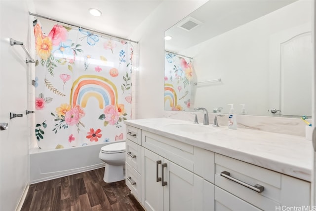 full bathroom featuring vanity, hardwood / wood-style flooring, shower / bath combination with curtain, and toilet