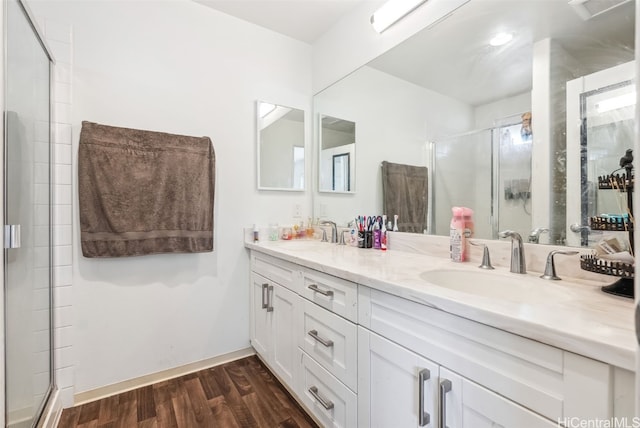 bathroom with wood-type flooring, an enclosed shower, and vanity