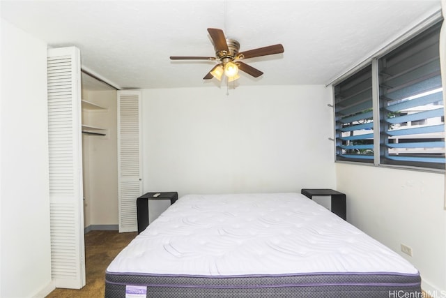 carpeted bedroom with ceiling fan and a closet