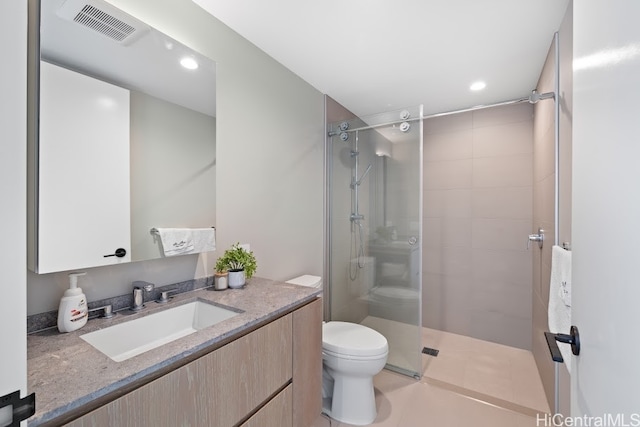 bathroom featuring vanity, tile patterned floors, toilet, and walk in shower