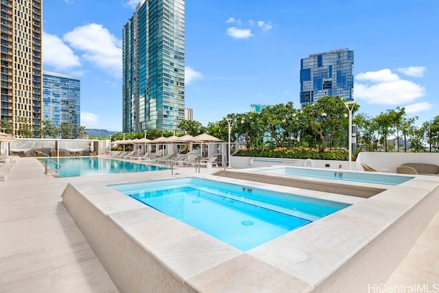 view of pool featuring a hot tub and a patio