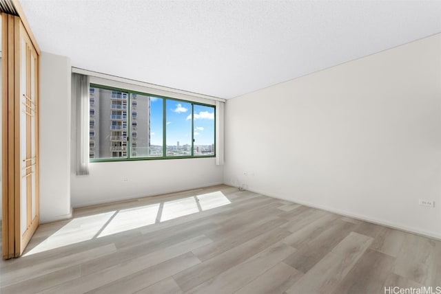 unfurnished bedroom with a textured ceiling and light wood-type flooring