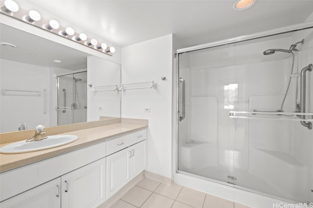 bathroom featuring vanity, a shower with shower door, and tile patterned flooring