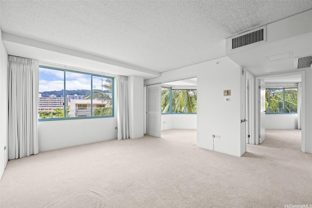 1314 Kalakaua Ave Unit 413, Honolulu, HI 96826 - empty room featuring carpet flooring, plenty of natural light, and a textured ceiling