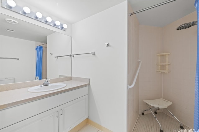 bathroom with vanity, tile patterned floors, toilet, and walk in shower