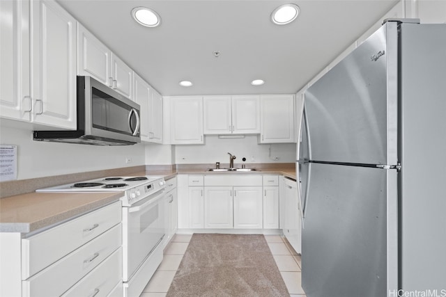 kitchen featuring sink, appliances with stainless steel finishes, light tile patterned floors, and white cabinets