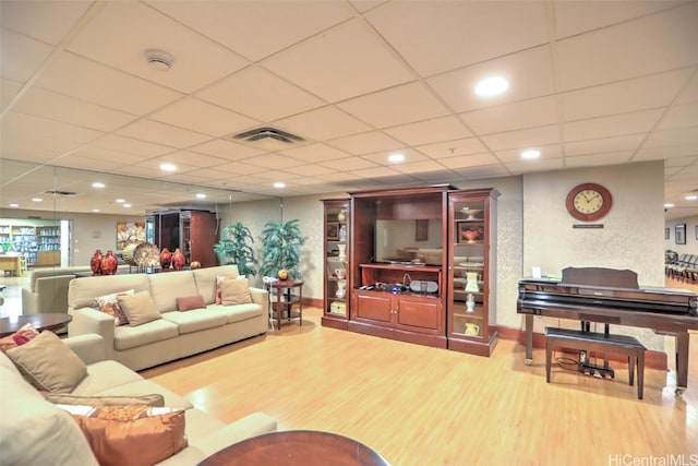 living room featuring a paneled ceiling and light wood-type flooring