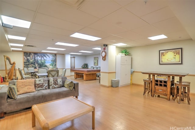 living room featuring a drop ceiling and light wood-type flooring