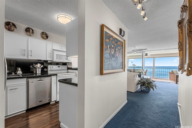 2877 Kalakaua Ave Unit 503/504, Honolulu, HI 96815 - kitchen with white appliances, a textured ceiling, dark countertops, white cabinets, and decorative backsplash